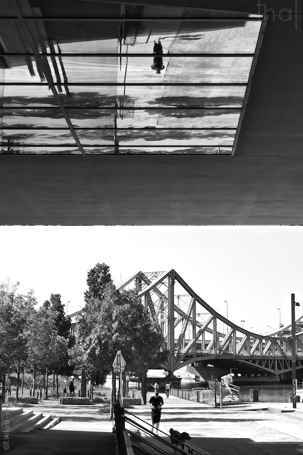 Reflet d'un coureur sous un immeuble à Lyon Confluence